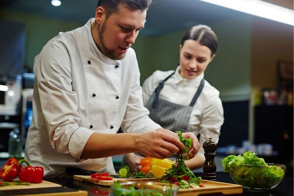Zwei Köche bereiten frischen Salat zu in der Küche im Hotel in Bad Gögging 